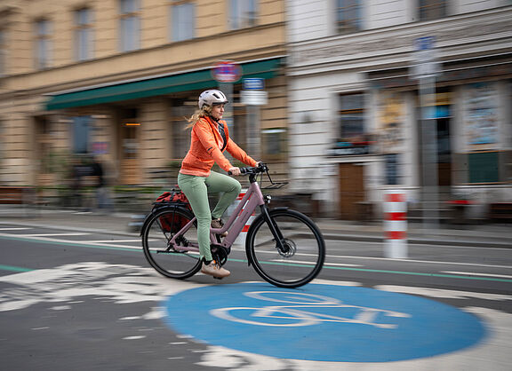 Frau auf dem Rad in der Stadt